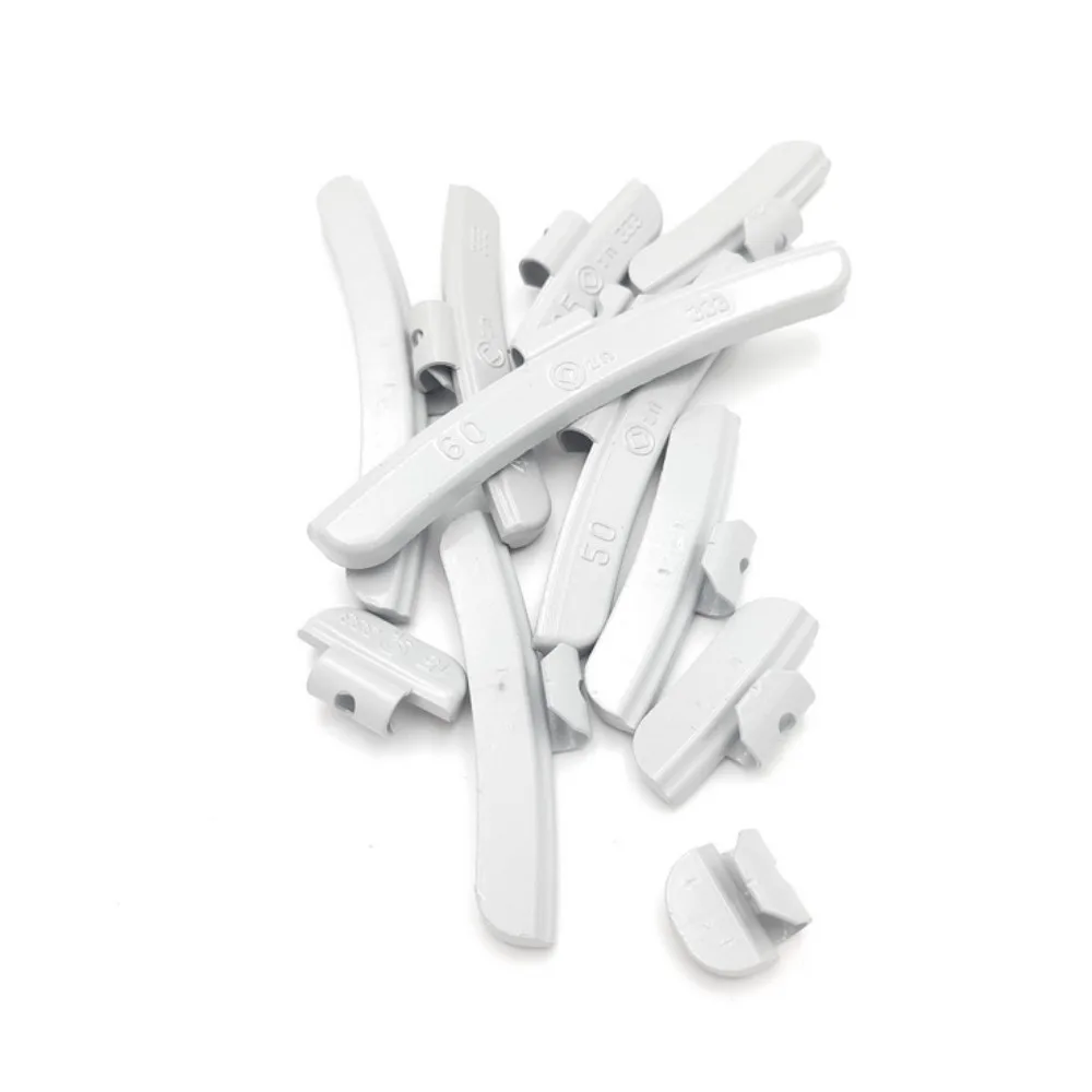 Gråa däckbalanseringsvikter i en hög.